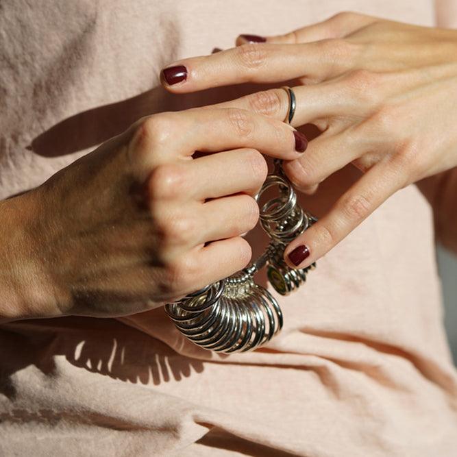 A person uses a ring sizer to check the size of their finger